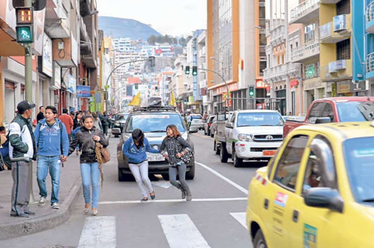 Dos transe&uacute;ntes cruzan la avenida Cevallos, en el centro de Ambato, a toda prisa, pese a que el sem&aacute;foro peatonal exhibe luz roja. Esta es una de las principales causas de arrollamientos. Fotos: Roberto Ch&aacute;vez / El Tel&eacute;grafo