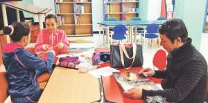 Gustavo Armijos, su hija Diana, de 12 a&ntilde;os, y una compa&ntilde;era disfrutan una tarde de tareas en la biblioteca. Foto: Jos&eacute; Miguel Castillo / El Tel&eacute;grafo
