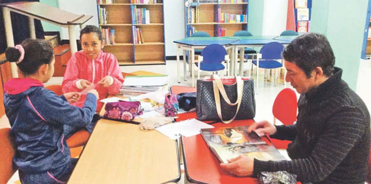 Gustavo Armijos, su hija Diana, de 12 a&ntilde;os, y una compa&ntilde;era disfrutan una tarde de tareas en la biblioteca. Foto: Jos&eacute; Miguel Castillo / El Tel&eacute;grafo
