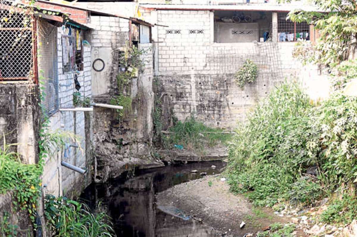Habitantes de la manzana 608 de la cooperativa Pancho J&aacute;come tienen que desfogar los l&iacute;quidos directamente en una zanja llena de basura y maleza, porque carecen de alcantarillado. Foto: Carina Acosta.