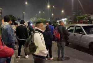 Usuarios esperan buses en la madrugada mientras rige reducci&oacute;n de horarios y toque de queda en Quito.