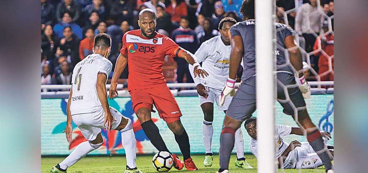 El delantero marfile&ntilde;o Didier Drogba se abri&oacute; paso en medio de los defensas de Liga, Horacio Salaberry y Jos&eacute; Quintero, ayer en Casa Blanca. 