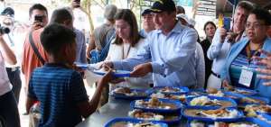 El secretario de salud de Estados Unidos, Alex M. Azar (c), entrega un plato de comida a un joven venezolano en el comedor Divina Providencia en C&uacute;cuta (Colombia).