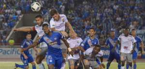 Los zagueros Gabriel Achilier, de Emelec, y Pablo Saucedo, de Delf&iacute;n, intentan despejar la pelota con la cabeza.