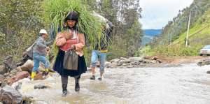 En Azuay, una mujer atraviesa por una v&iacute;a que fue bloqueada por agua y piedras debido a un derrumbe. Cortes&iacute;a MIES