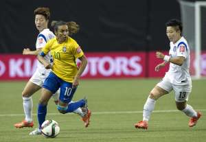 La jugadora Marta evade la marca de 2 jugadoras coreanas. Foto: AFP