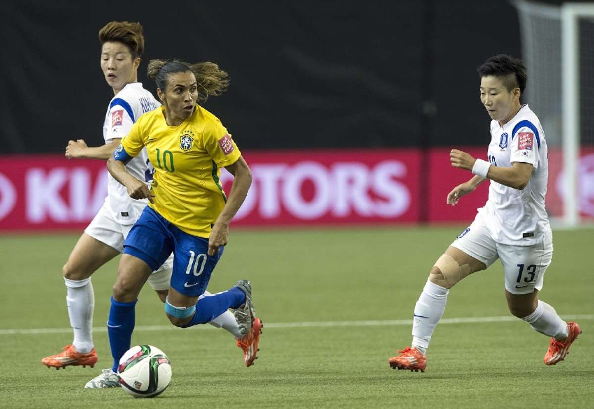 La jugadora Marta evade la marca de 2 jugadoras coreanas. Foto: AFP