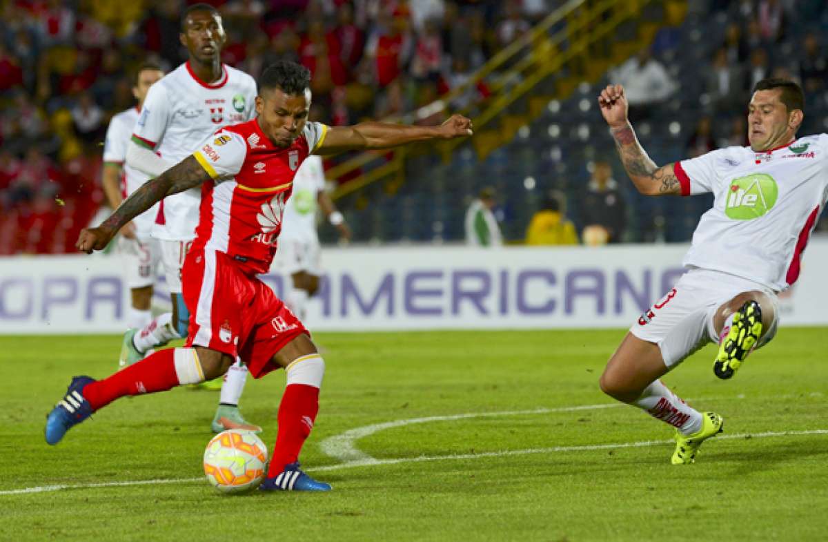 Wilson Moreno (rojo) fue la figura del partido, la noche de ayer, en Bogot&aacute;, al convertir los tres goles de su equipo, el Santa Fe. Foto: AFP