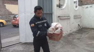 Un agente de polic&iacute;a sostiene en sus brazos el cart&oacute;n con un saco de yute en donde se encontr&oacute; al beb&eacute;. Foto: Elizabeth Maggi / El Tel&eacute;grafo
