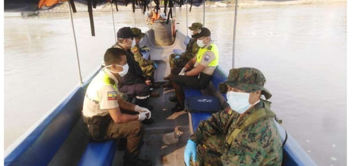 Personal militar y ciudadanos hacen trasbordos utilizando mascarillas.