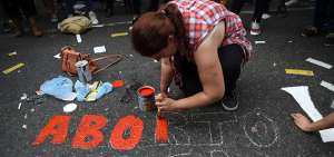 Una mujer pinta una leyenda sobre aborto legal seguro y gratuito en Argentina. El martes se efectu&oacute; una manifestaci&oacute;n afuera del Congreso. 