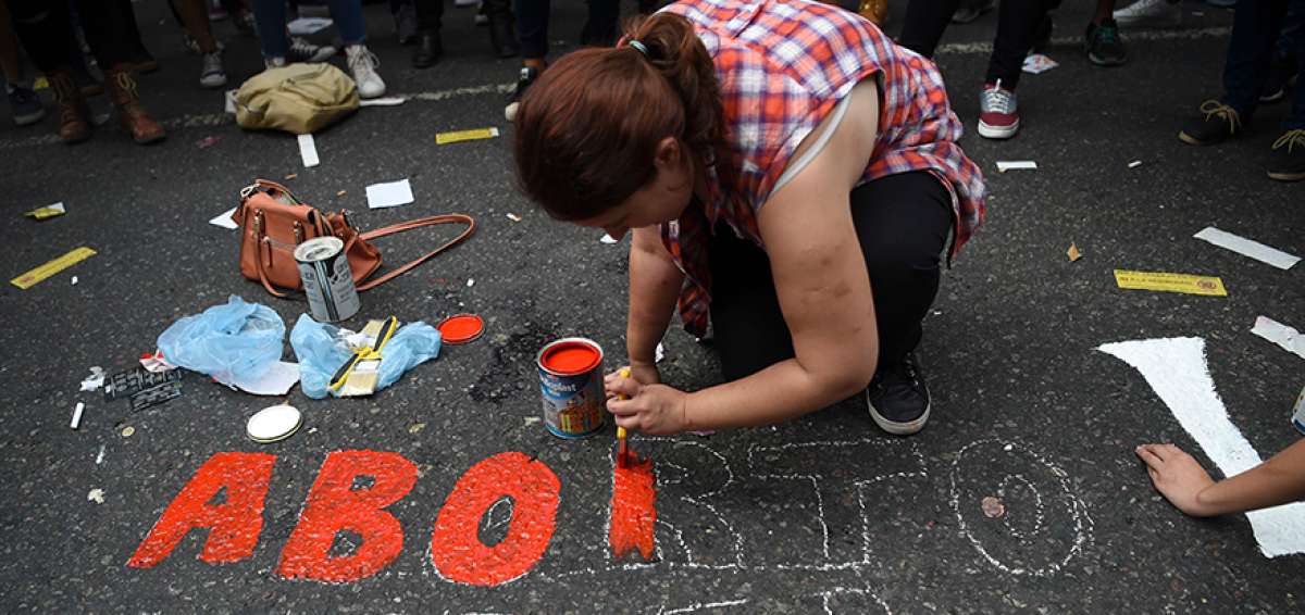 Una mujer pinta una leyenda sobre aborto legal seguro y gratuito en Argentina. El martes se efectu&oacute; una manifestaci&oacute;n afuera del Congreso. 