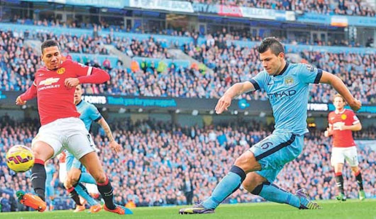 El zaguero Chris Smalling (iz.) intenta detener el remate del argentino Sergio Ag&uuml;ero (d.) durante la victoria del &lsquo;City&rsquo; ayer ante el &lsquo;United&rsquo;. Foto: AFP
