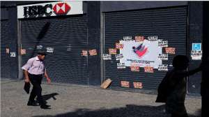 Un transe&uacute;nte camina frente a una sucursal cerrada banco HSBC Brasil- , en el centro de R&iacute;o de Janeiro. Foto: AFP
