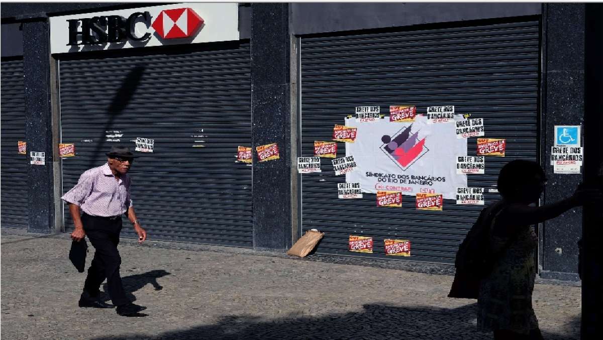 Un transe&uacute;nte camina frente a una sucursal cerrada banco HSBC Brasil- , en el centro de R&iacute;o de Janeiro. Foto: AFP
