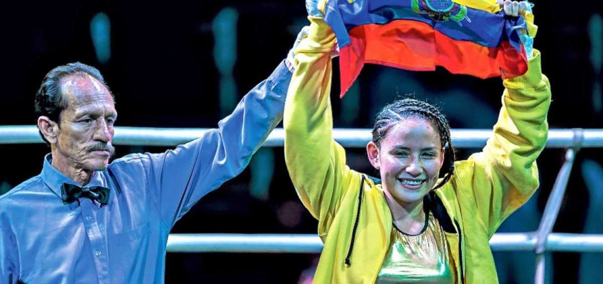 La boxeadora ecuatoriana Jhosep Vizca&iacute;no celebra con la bandera ecuatoriana, tras vencer a Paulina Cardona.