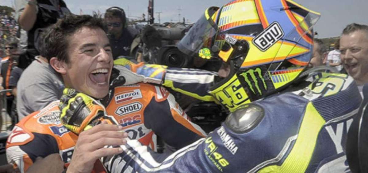 Valentino Rossi (d) bromea, tomando del cuello a Marc M&aacute;rquez, en el circuito de Laguna Seca en 2013.
