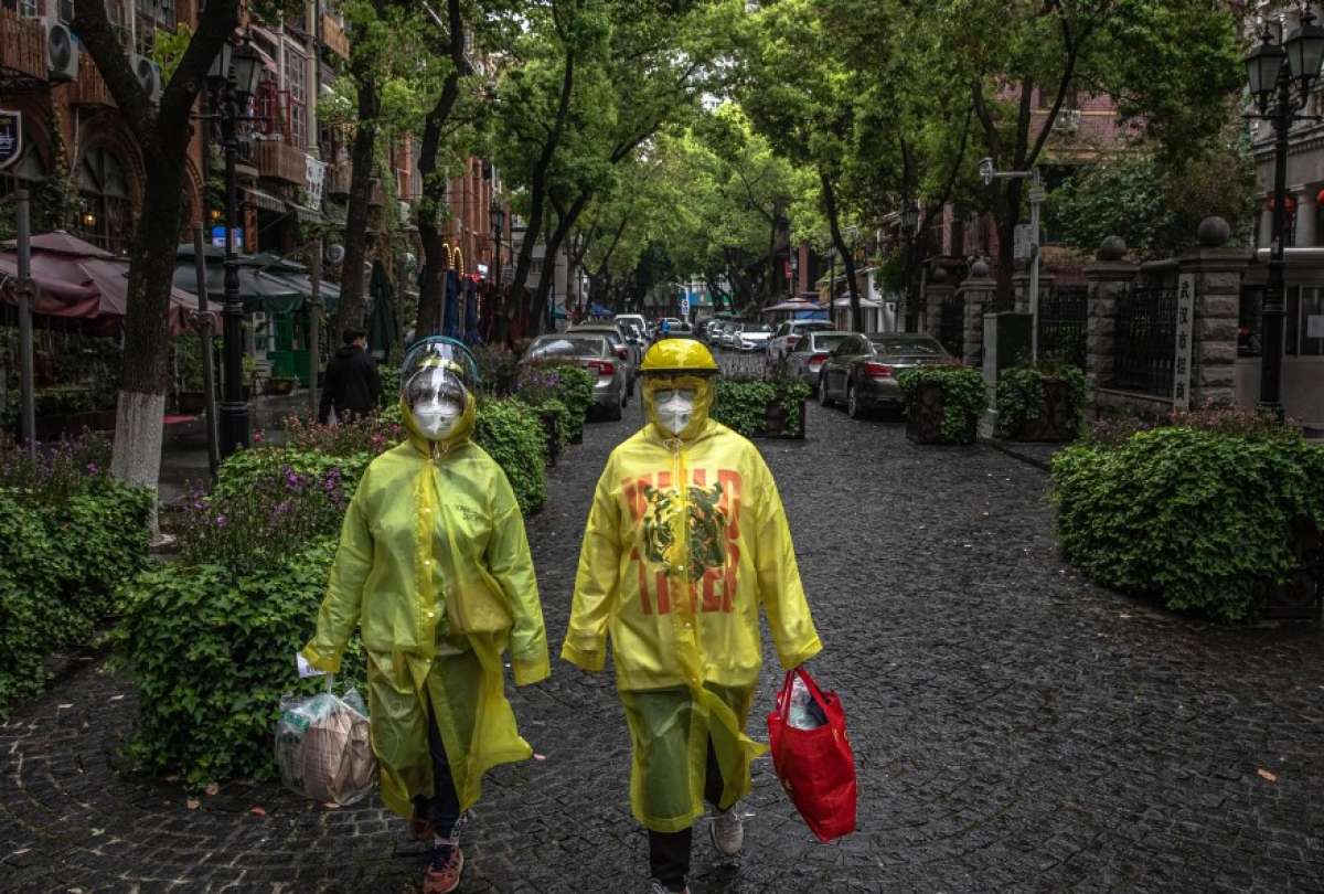 Wuhan (China).- Dos personas con traje de protecci&oacute;n en una calle de Wuhan, epicentro del coronavirus.