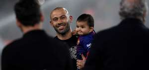 El defensor Javier Mascherano sonr&iacute;e junto a su hijo, el d&iacute;a de su despedida del Barcelona en el estadio Camp Nou.  
