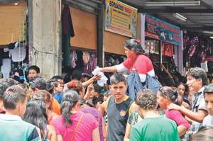 La comerciante Carolina Espinoza coloc&oacute; un asiento y sobre este, en la acera, comenz&oacute; a ofertar ropa en las calles Sucre y 6 de Marzo. Foto: Lylibeth Coloma.