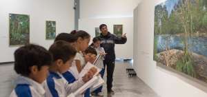 El maestro Eduardo Acosta explica a sus alumnos, de la Escuela Particular Valdivia, quienes cursan el sexto a&ntilde;o de b&aacute;sica, una pintura de Ram&oacute;n Piaguaje.