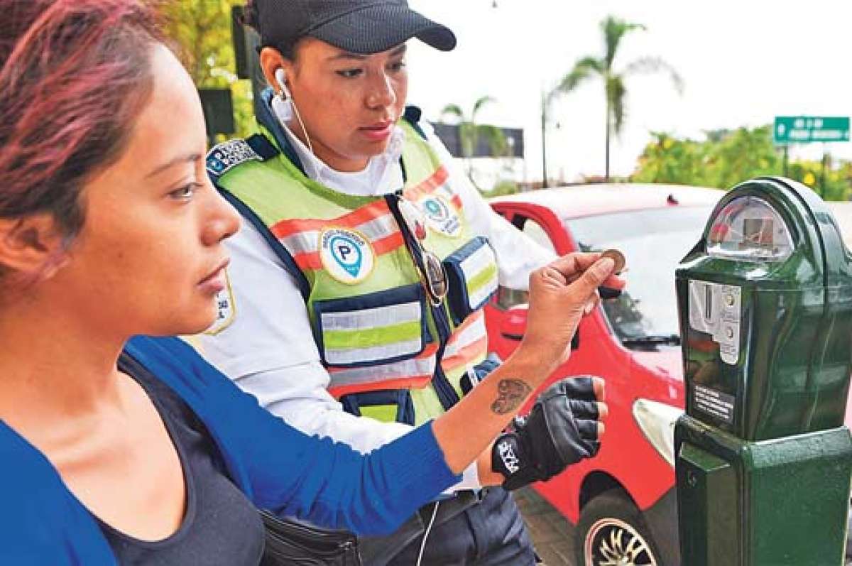 Los agentes de la ATM indican a los ciudadanos la forma de usar los parqu&iacute;metros del sector. Foto:  William Orellana / El Tel&eacute;grafo