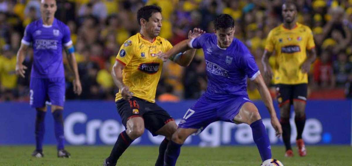 Oyola (amarillo) disputando el bal&oacute;n con un jugador del Defensor Sporting.
