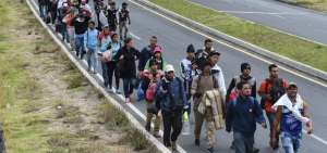 Un grupo de venezolanos avanzan por una carretera de Tulc&aacute;n, Ecuador.