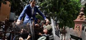 El l&iacute;der opositor venezolano Juan Guaid&oacute; trep&oacute; una reja en un intento por ingresar a la sede de la Asamblea Nacional, custodiada por la polic&iacute;a para impedir su ingreso y el de diputados opositores este domingo, en Caracas (Venezuela).