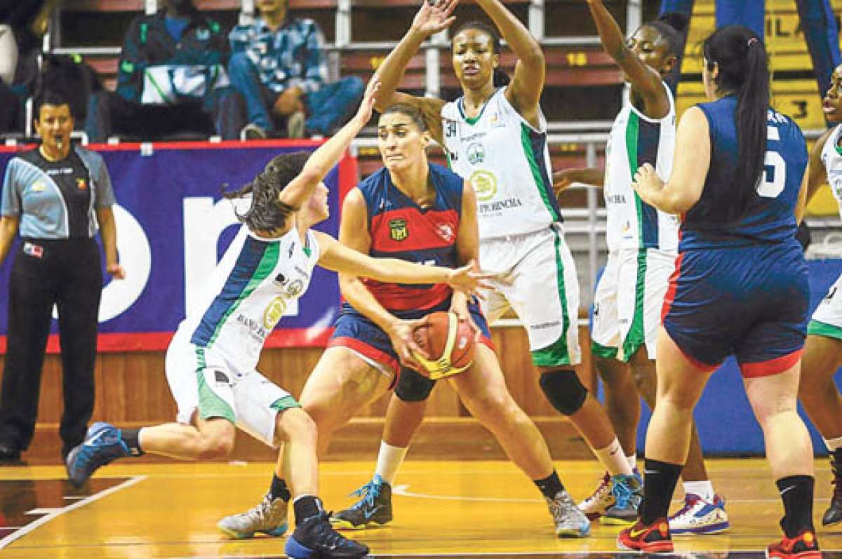 La argentina Gisella Vega (centro), de Santa Mar&iacute;a, protege la pelota ante la marca rival. Foto: Cortes&iacute;a Ministerio del Deporte.