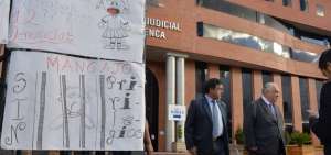En los exteriores del Complejo Judicial de Cuenca, se colocaron carteles para expresar el rechazo contra el agresor. A un costado, el abogado de la v&iacute;ctima, Caupolic&aacute;n Ochoa.
