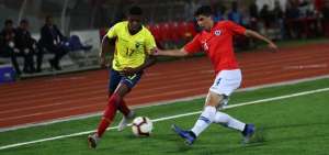 El volante ecuatoriano John Mercado (izq.) controla el bal&oacute;n ante la marca del lateral chileno Cristian Riquelme.