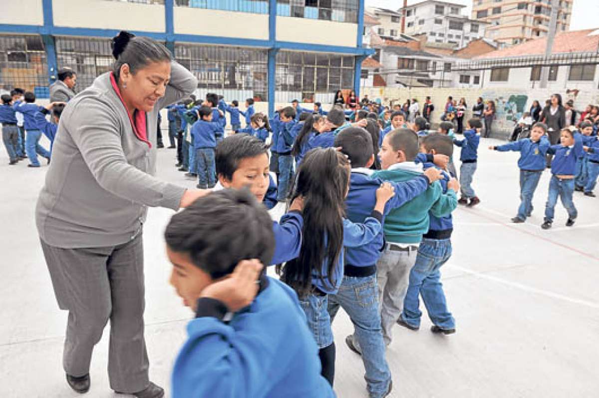 Mientras salen del aula, los estudiantes deben cubrirse la cabeza para evitar que alg&uacute;n objeto de la parte alta caiga por el sismo y los lastime. Foto: Jos&eacute; Luis LLivisaca.
