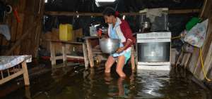 Edilma Ponce, de la cooperativa Hermano Gregorio 2 (Dur&aacute;n), intenta rescatar sus enseres del agua.
