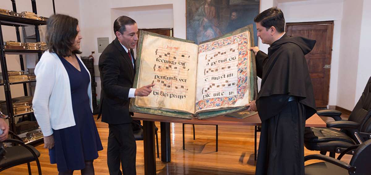 Desde la izquierda: Edith Mart&iacute;nez, invitada; Ramiro Endara, director de Conservartecuador; y Fray Wilson Posligua con el libro coral de San Agust&iacute;n .  