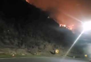 Las llamas del incendio forestal se observan desde la carretera Baños-Pelileo.  
