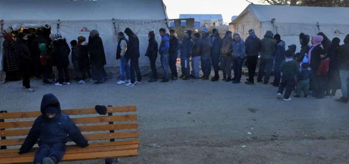 Migrantes y refugiados hacen cola para recibir la ropa , ya que esperar para cruzar la frontera de Grecia a Macedonia cerca Idomeni.