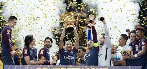 El delantero franc&eacute;s Kylian Mbapp&eacute; levanta el t&iacute;tulo de la Copa de la Liga, mientras sus compa&ntilde;eros celebran al final del partido contra el M&oacute;naco. 