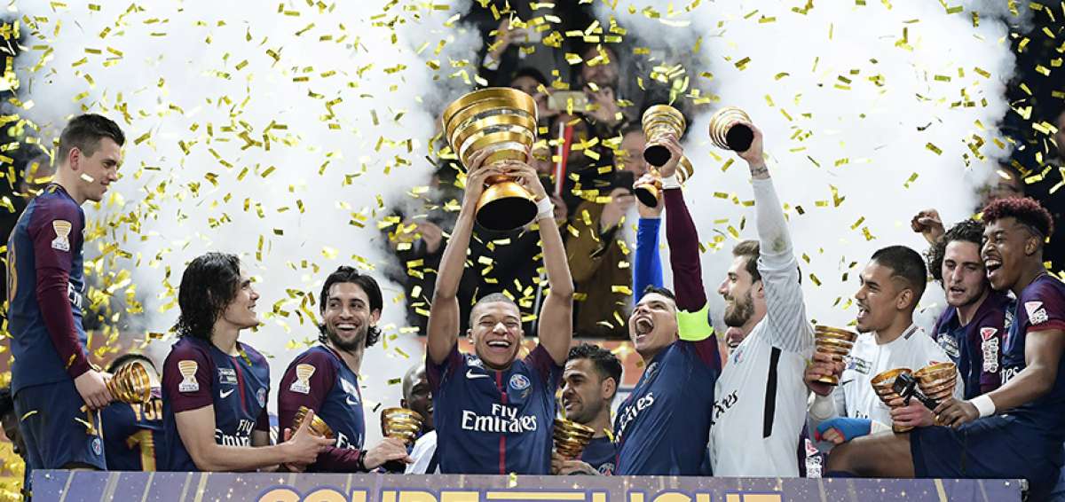 El delantero franc&eacute;s Kylian Mbapp&eacute; levanta el t&iacute;tulo de la Copa de la Liga, mientras sus compa&ntilde;eros celebran al final del partido contra el M&oacute;naco. 