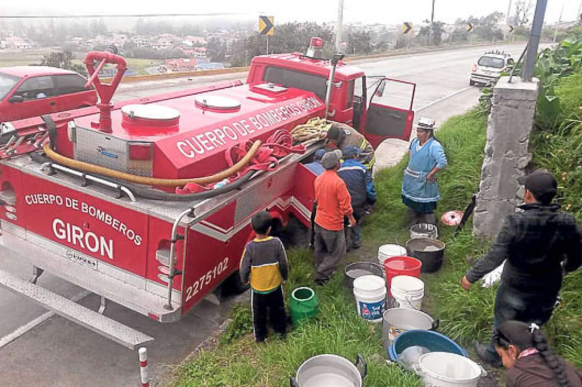 Un veh&iacute;culo del Cuerpo de Bomberos provee del l&iacute;quido a los ciudadanos afectados por el da&ntilde;o de la tuber&iacute;a en el cant&oacute;n Gir&oacute;n. Foto: Eloy Peralta / para El Tel&eacute;grafo