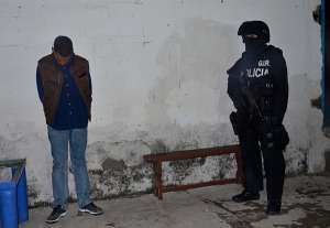Un agente del GIR vigila a uno de los cuatro sospechosos del presunto triple asesinato. Foto: Cortes&iacute;a 