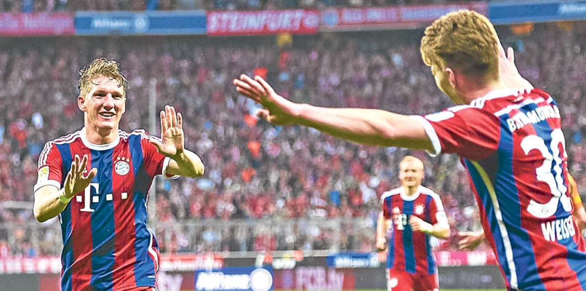 El mediocampista Bastian Schweinsteiger (izq.) festeja el triunfo del s&aacute;bado pasado ante el Hertha de Berl&iacute;n. Foto: AFP