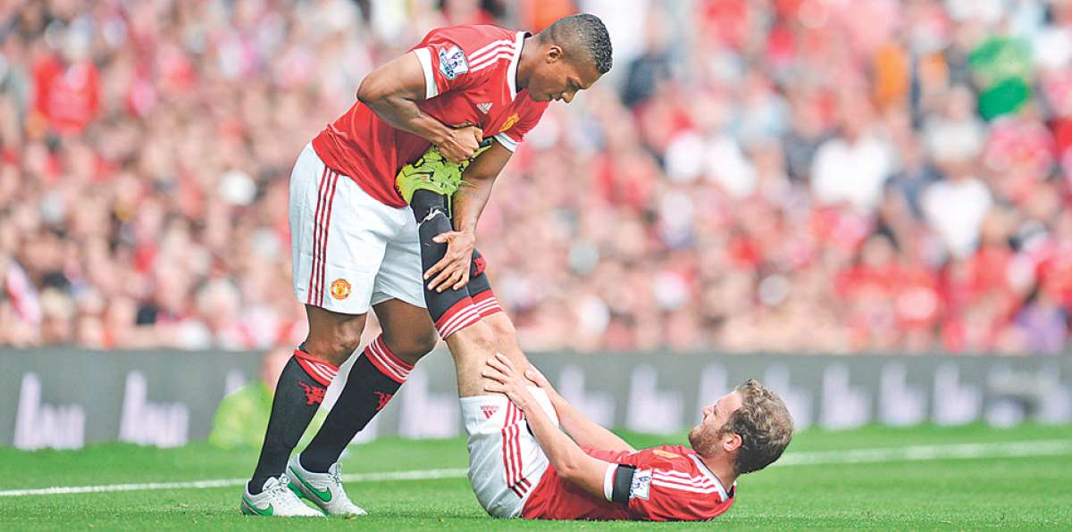 Antonio Valencia ayuda a su compa&ntilde;ero, el espa&ntilde;ol Juan Mata, a recuperarse de un dolor en su pierna zurda. Foto: AFP