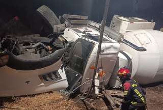  Personal de emergencia trabaja en el retiro del vehículo volcado en el sector de Guajaló, al sur de Quito.