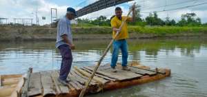 Luis Loor (i) ayuda a Carlos Cevallos a pasar el r&iacute;o tras da&ntilde;arse el puente en La Madera.