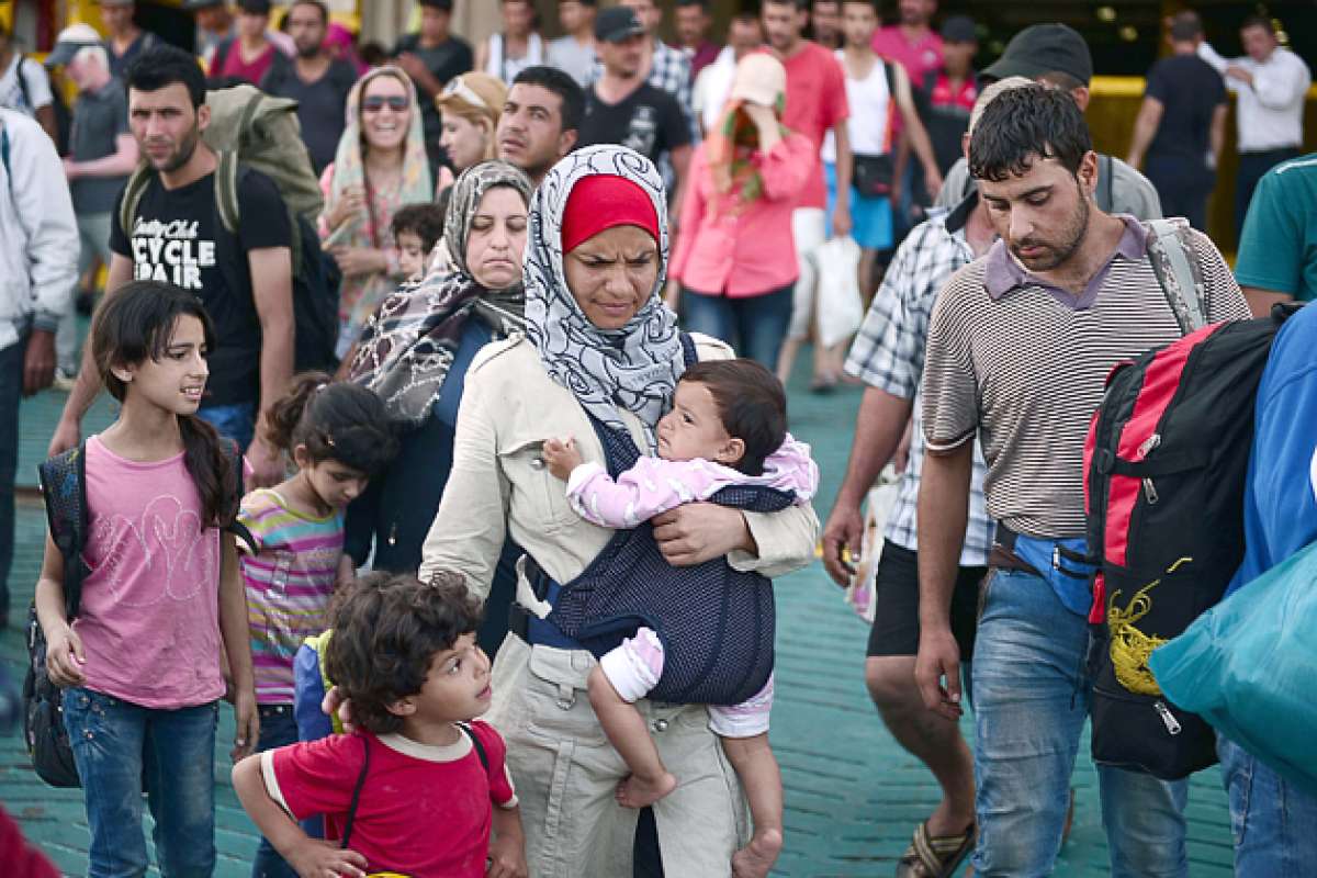 Una mujer siria llega con sus hijos y otros inmigrantes al puerto de El Pireo, cerca de Atenas. Foto: AFP