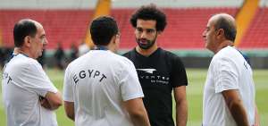 Mohamed Salah (negro), seleccionado de Egipto, conversa con integrantes del cuerpo t&eacute;cnico y m&eacute;dico, antes de realizar pr&aacute;cticas solo. Sus compa&ntilde;eros hicieron ejercicios bajo el mando de H&eacute;ctor C&uacute;per.