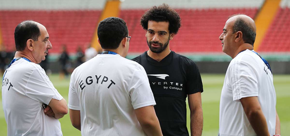 Mohamed Salah (negro), seleccionado de Egipto, conversa con integrantes del cuerpo t&eacute;cnico y m&eacute;dico, antes de realizar pr&aacute;cticas solo. Sus compa&ntilde;eros hicieron ejercicios bajo el mando de H&eacute;ctor C&uacute;per.