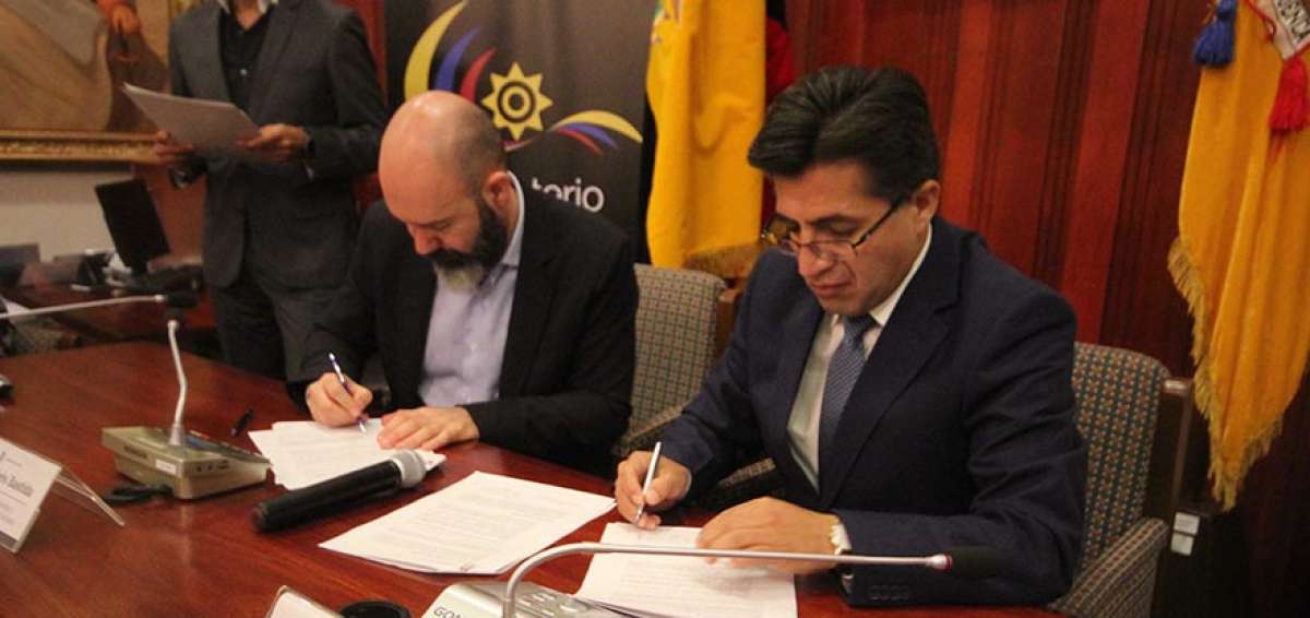 El rector de la Universidad de Cuenca, Pablo Vanegas (der.), firma el convenio para fortalecer el turismo dentro del pa&iacute;s con Andr&eacute;s Bastida.
