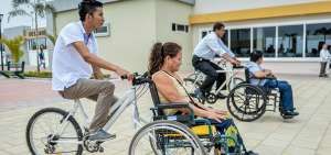 Jipson Palacios pasea a Adelina Espinales en una bicicleta donde adapt&oacute; una silla de ruedas.